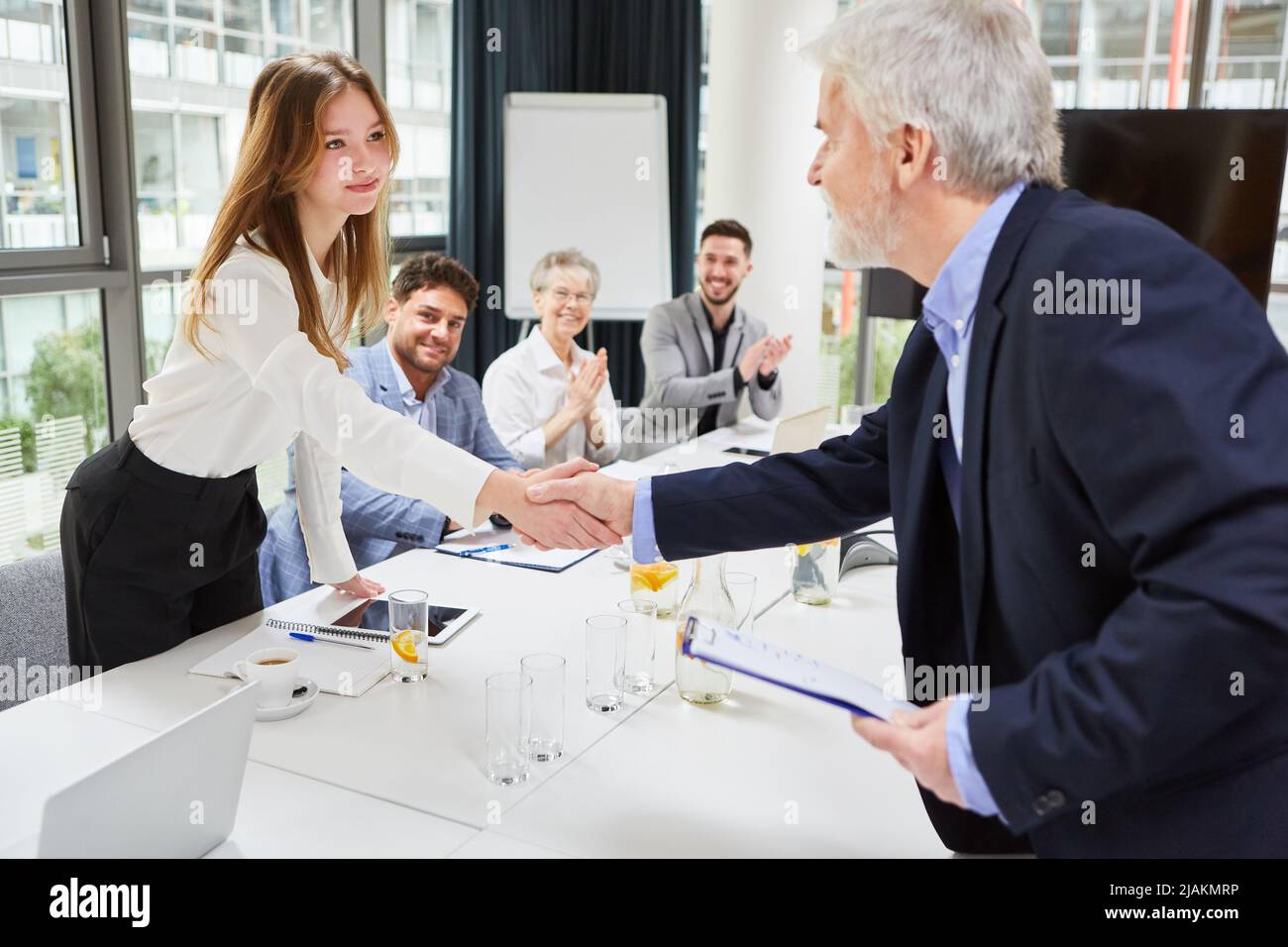 Businessman and businesswoman making handshake after successful business team meeting in office Stock Photo