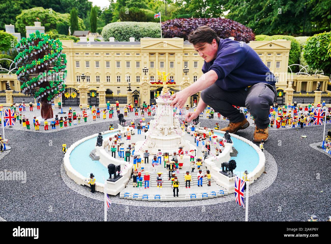A member of the LEGOLAND Windsor staff makes adjustments to a LEGO replica of the Queen Victoria Memorial set in front of a LEGO replica of Buckingham Palace. LEGOLAND Windsor Resort today