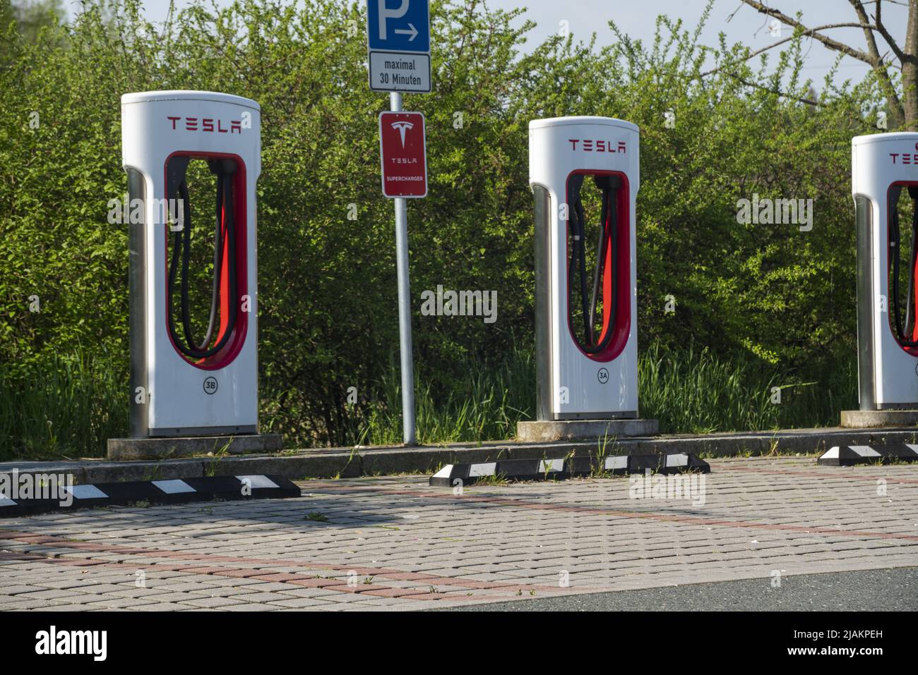 Tesla Superchargers against a backdrop of green trees Stock Photo Alamy