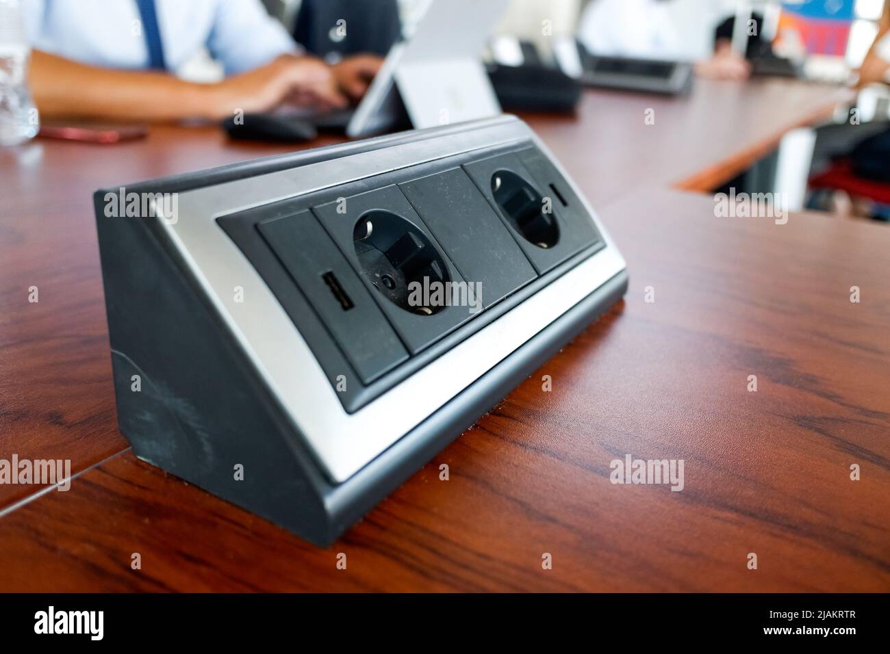 Station with electrical outlets on a desk in a work room. Stock Photo