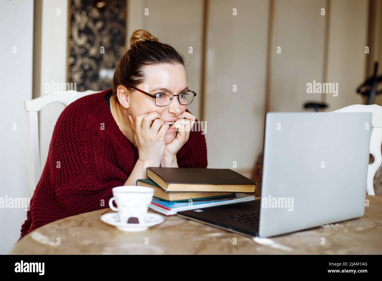 Tired and angry woman using laptop, online deals, remote job at home. Slow speed internet, downloading. Work problems Stock Photo