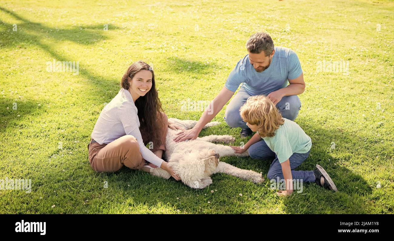 happy parents with kid boy play with dog. mom dad and son love relax ...