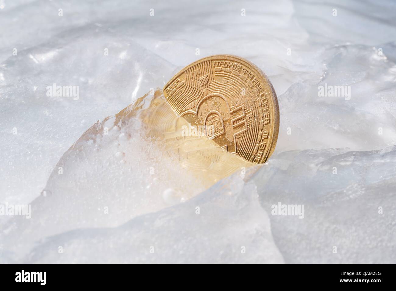 Golden coin with bitcoin symbol frozen in ice. Freezing of cryptocurrency, depreciation, legal and economic problems of the cryptocurrency market them Stock Photo