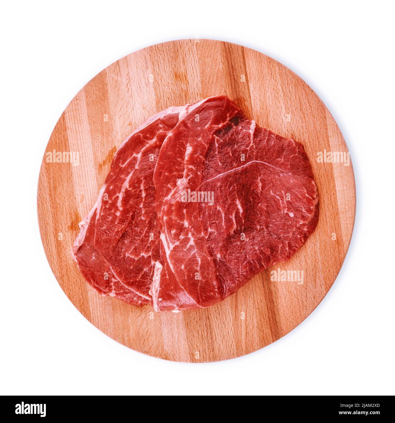 Raw meat for steak on round wooden cutting board. Top view isolated on white, clipping path included Stock Photo