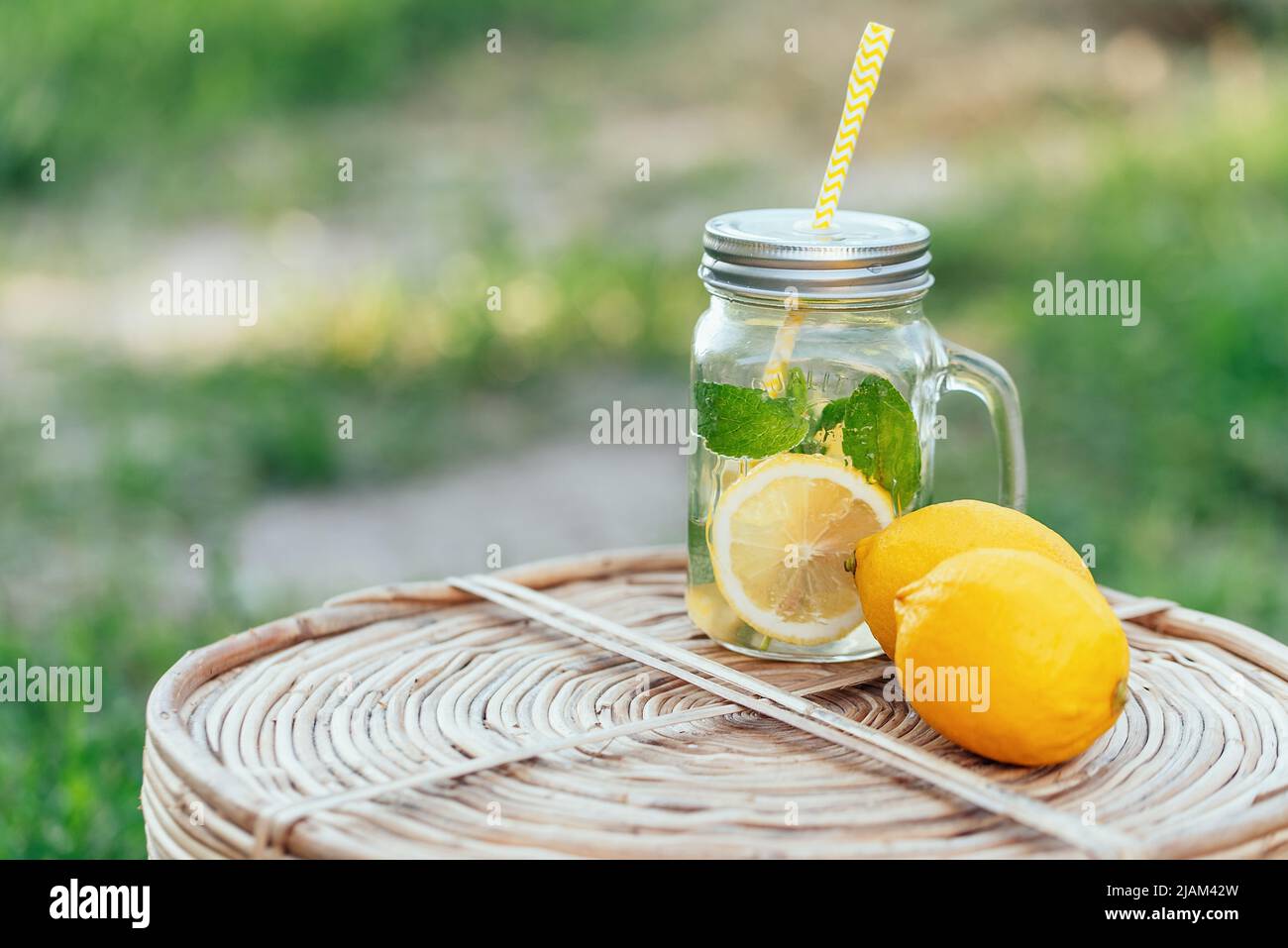 Plate with ripe fresh lemons and lemonade sassy water. Vitamins concept. copy space. Strengthening immunity concept. Tropical fruit. Organic citrus fruits for a healthy diet. Stock Photo