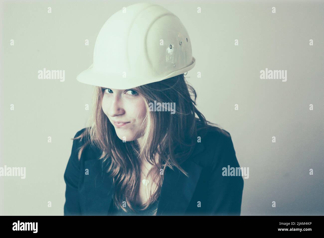 Pretty young woman with white hard hat Stock Photo