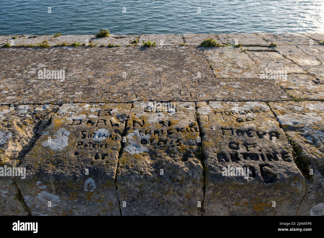 Names and dates etched in to the harbour wall at Saint-Martin-de-Re, in the west of France Stock Photo