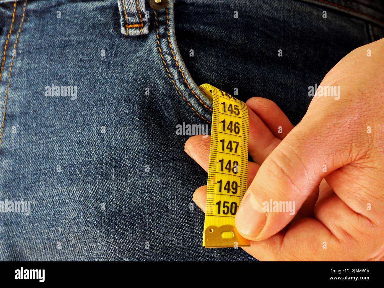 yellow measuring tape in a man's jeans pocket Stock Photo