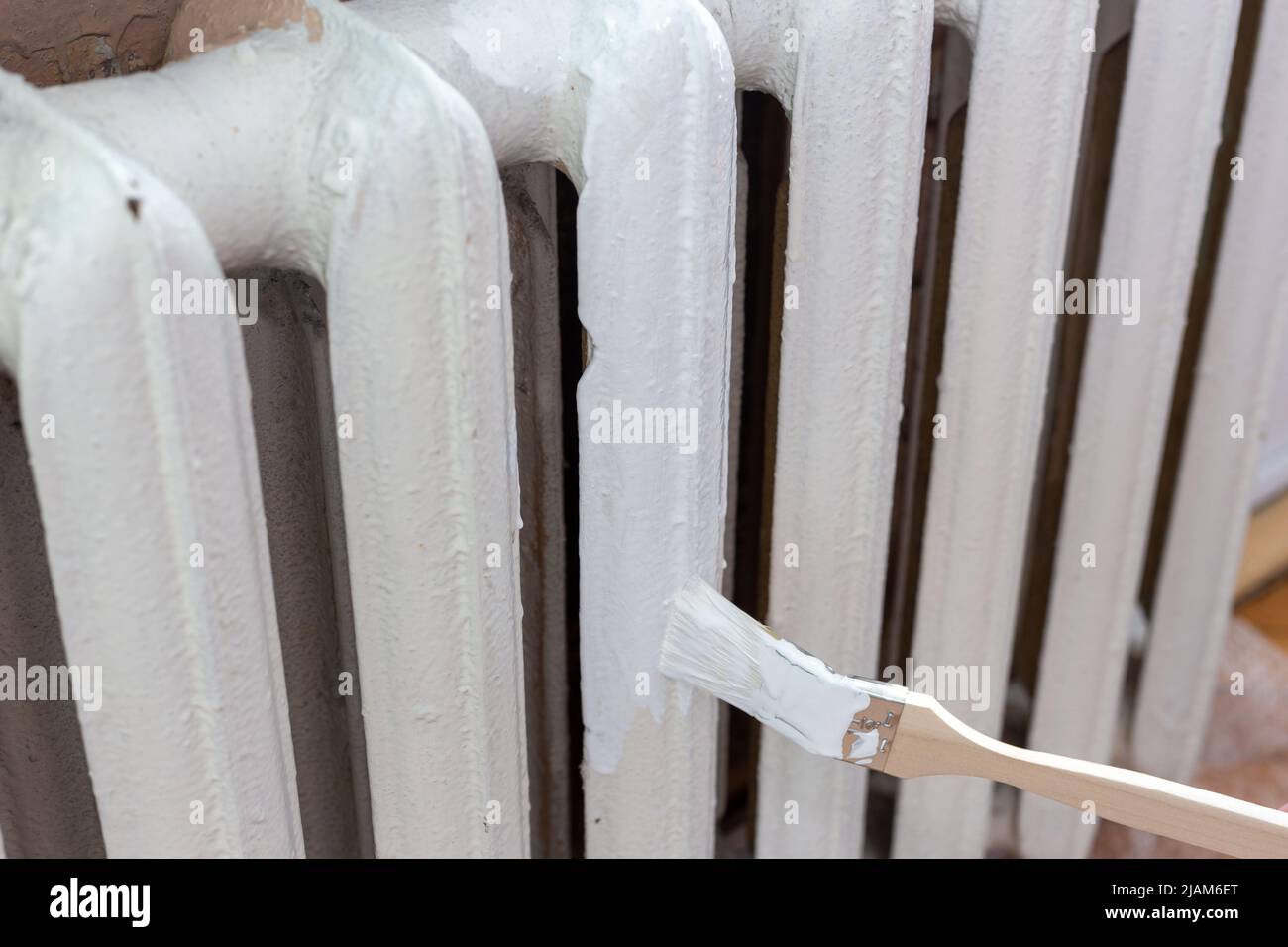 Painting radiators with a special brush. Battery painting Stock Photo