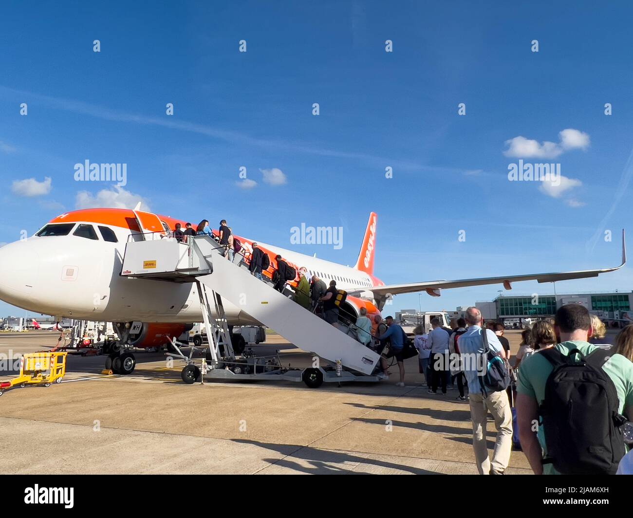 Passengers wait on the runway at London Gatwick to board an Easyjet flight to George best Belfast City Airport. Stock Photo