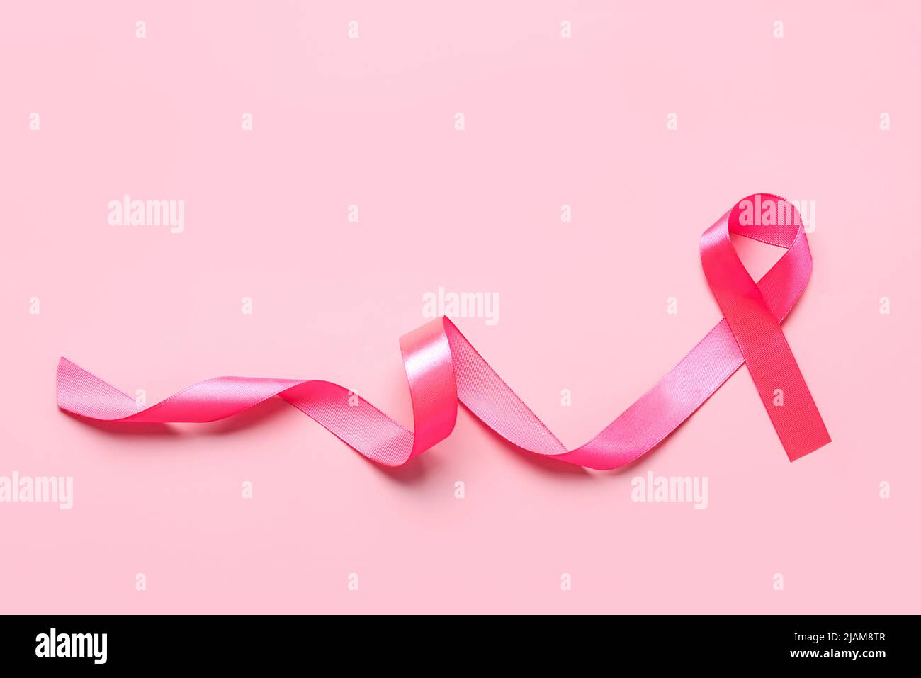 Top view of pink ribbon symbol breast cancer awareness with space for text over pink background Stock Photo