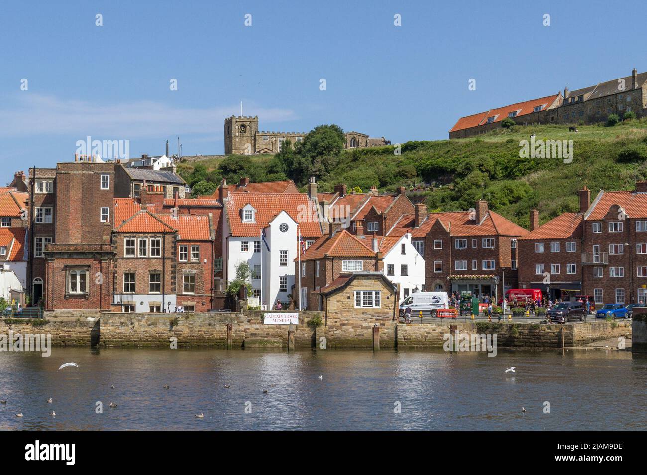 View across the River Esk and Whitby Harbour towards the Captain Cook Memorial Museum and Whitby Abbey in Whitby, North Yorkshire, England. Stock Photo