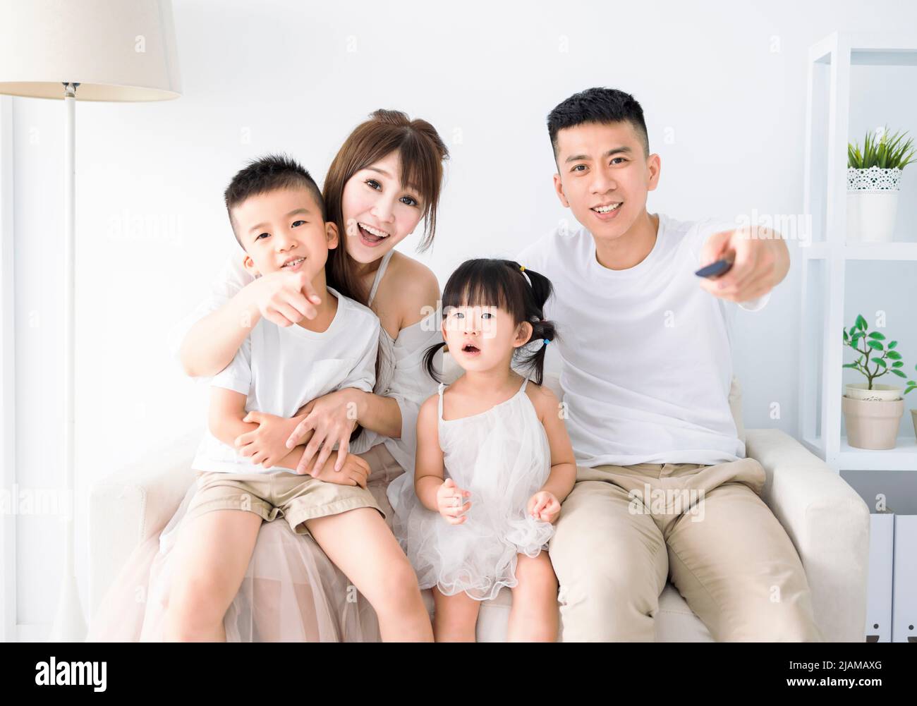 Happy young  family  watching the TV at home Stock Photo