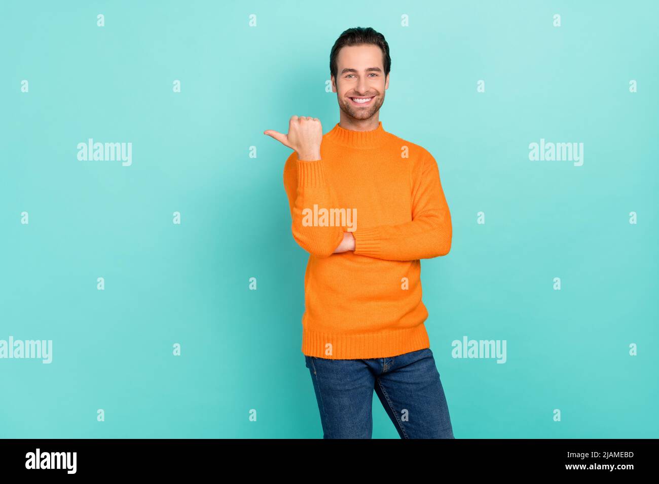 Portrait of positive person indicate thumb empty space proposition isolated on teal color background. Stock Photo