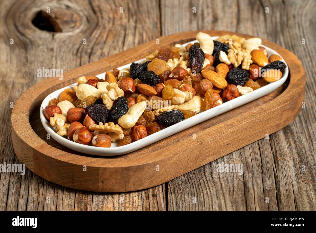 Mixed nuts on wooden background. Nuts, walnuts, raisins and cashews. close up Stock Photo