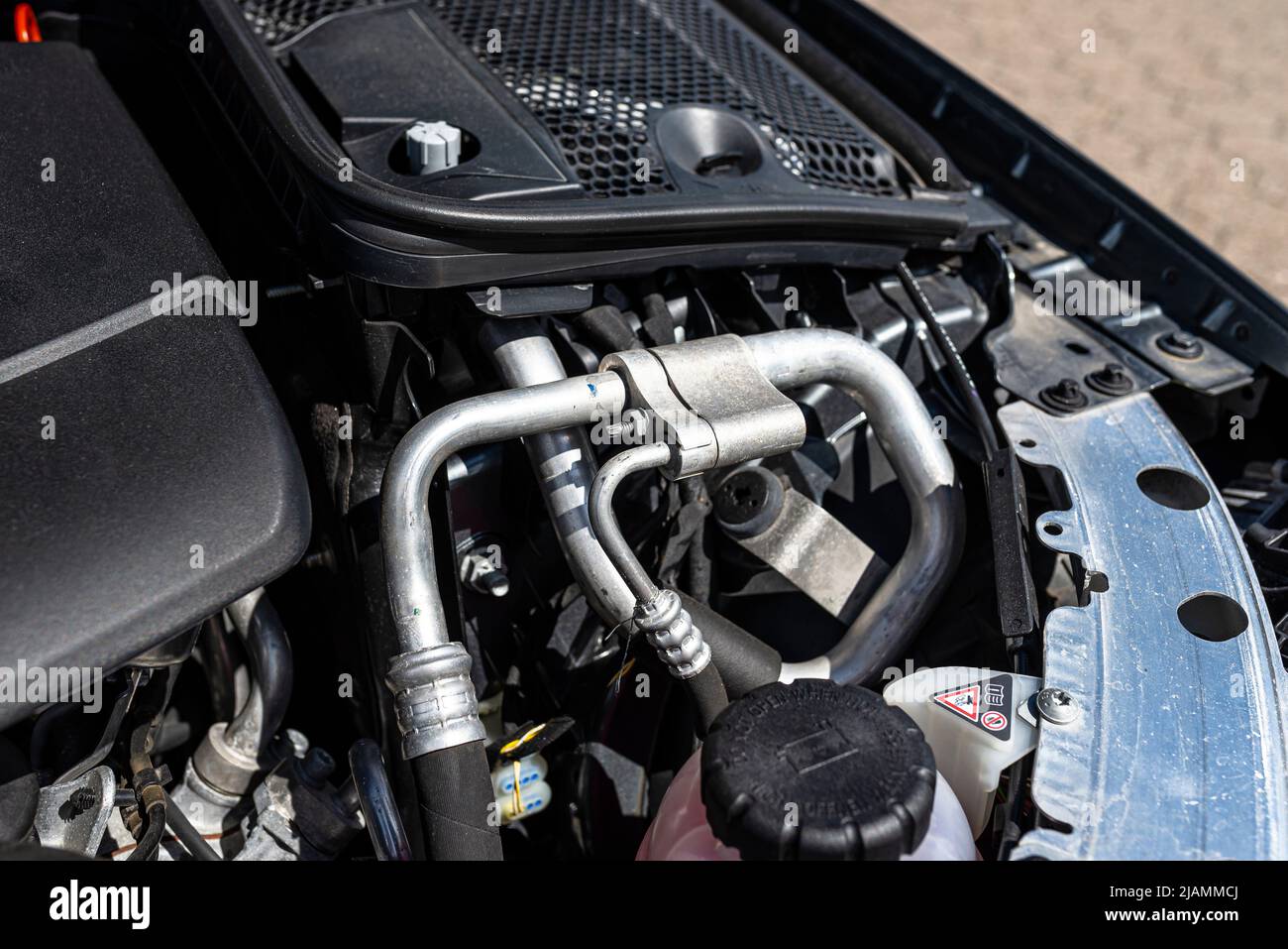 Aluminum air conditioning tubes with a cap, located in the diesel engine compartment. Stock Photo