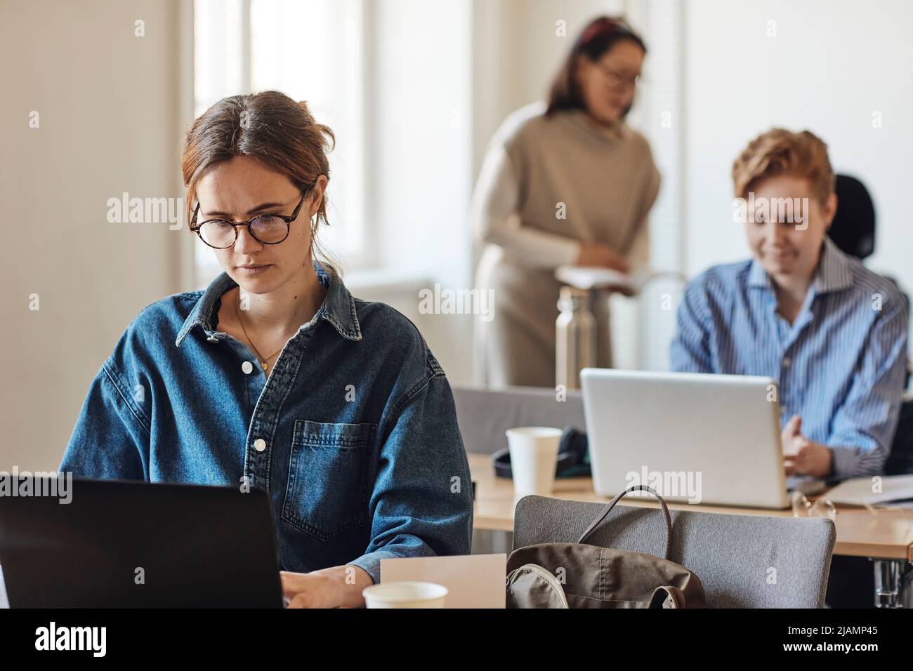 Dedicated female student using laptop while sitting at desk in classroom Stock Photo