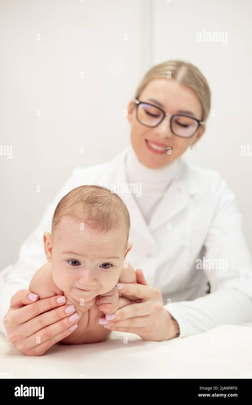 Female masseur doing baby massage for foot little infant baby child Stock Photo