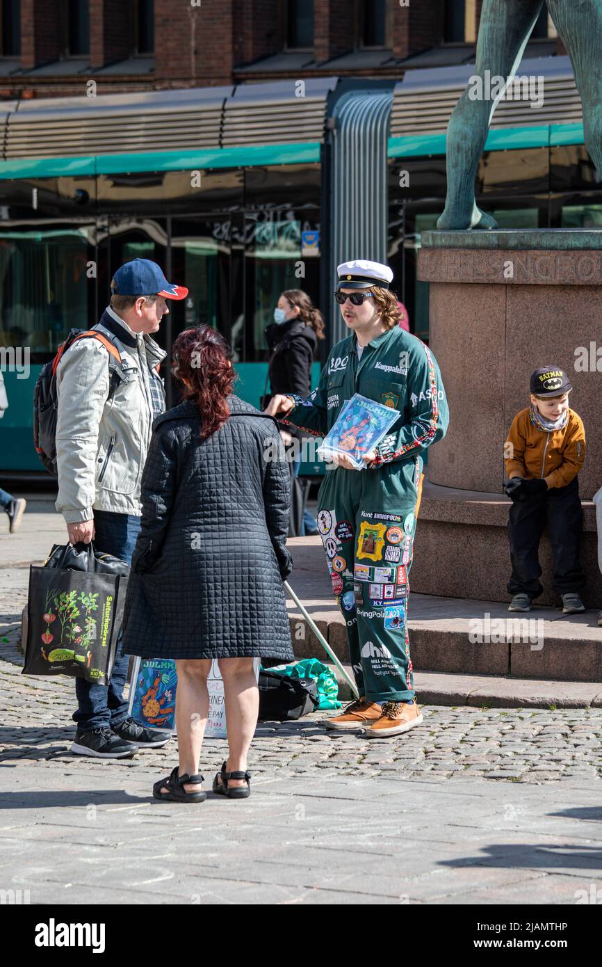 Engineering student in boilersuit selling Julkku humour magazine to passersby in Helsinki, Finland Stock Photo