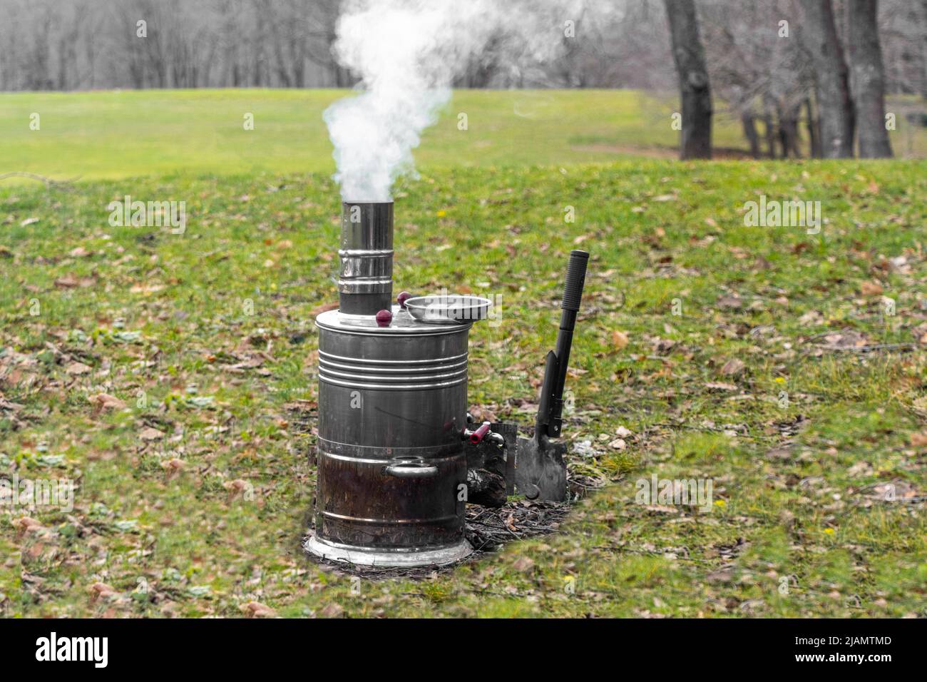 Samovar smoking and burning on the grass in nature. for tea and coffee at camping and picnic Stock Photo