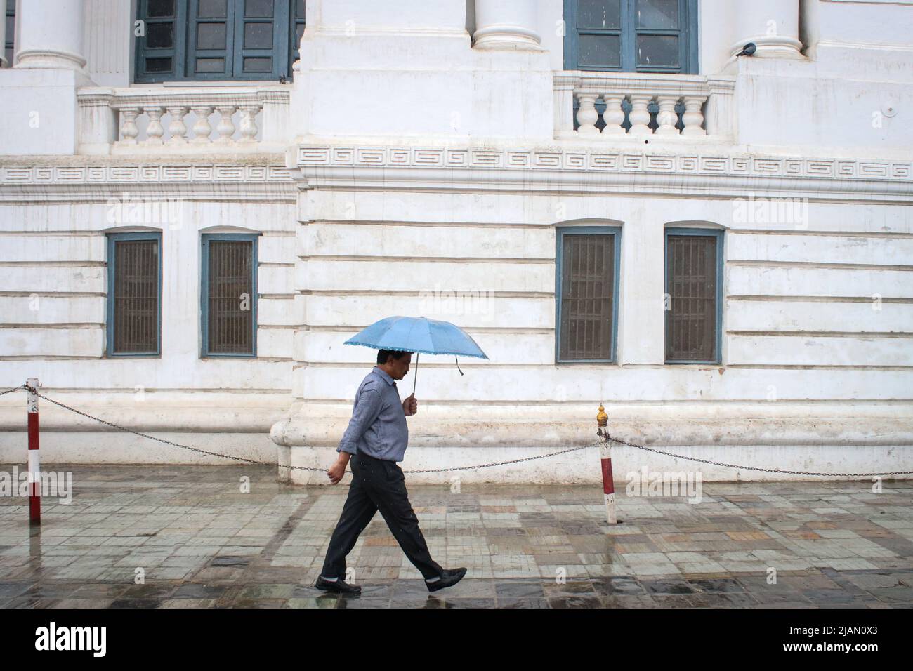 On May31, 2022 in Kathmandu, Nepal. A man carrying umbrella walks on