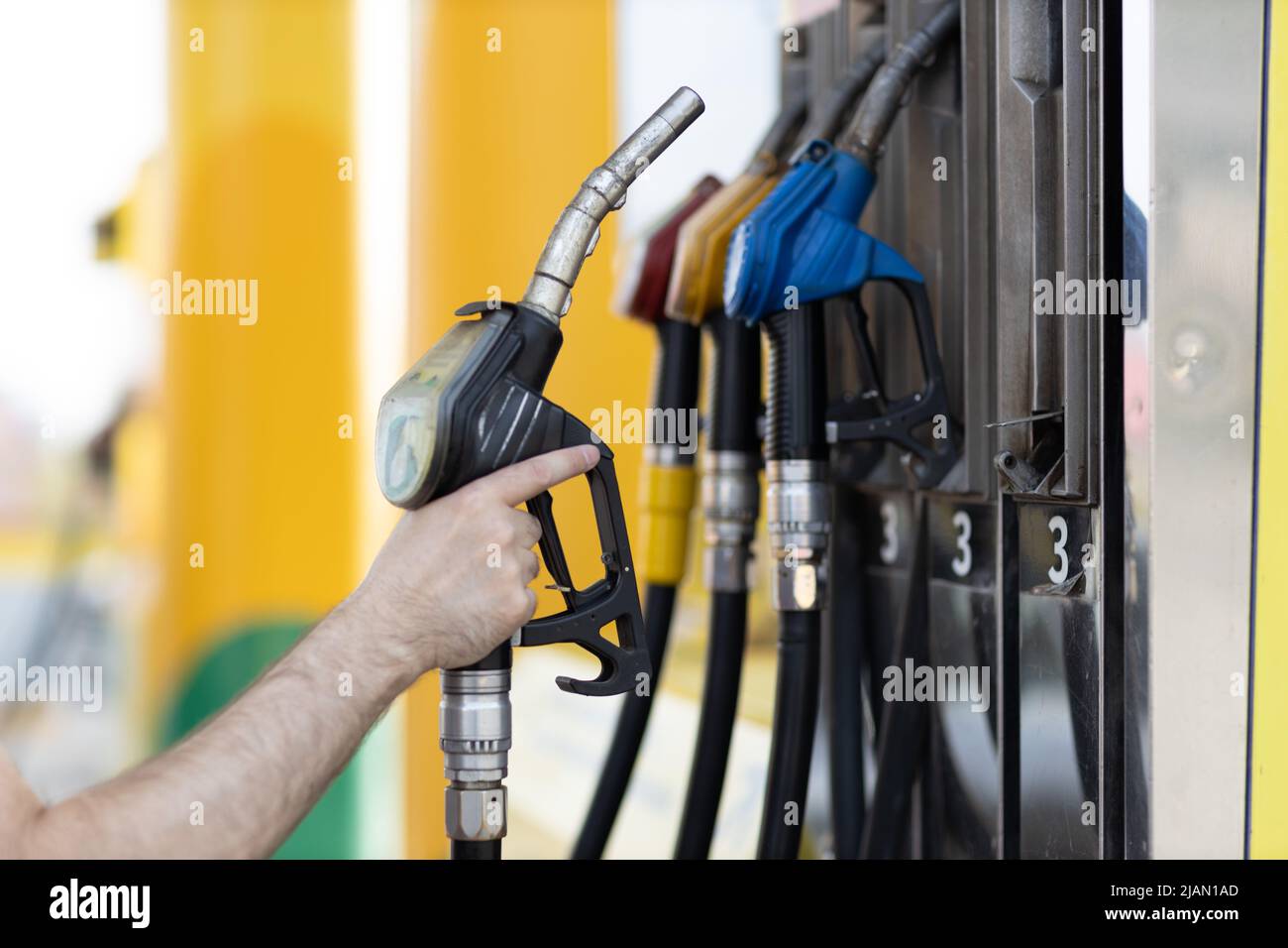 Man holding filling gun in his hand at gas station. Sanctions economy crisis concept Stock Photo