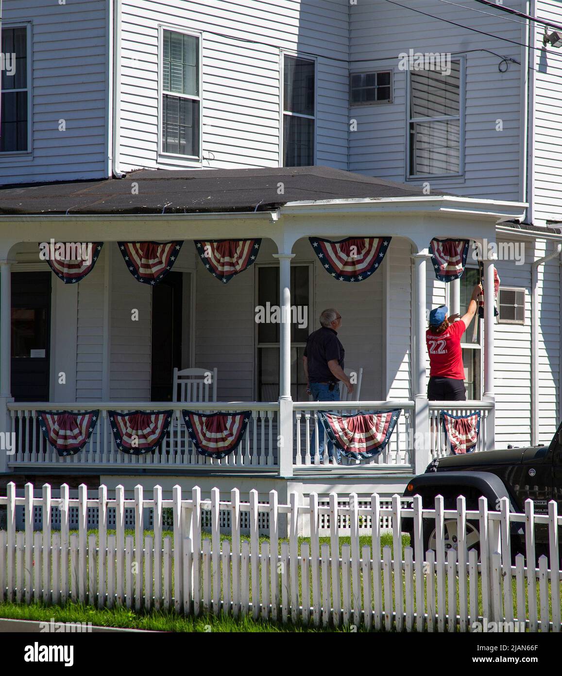 Man putting up patriotic bunting for the Fourth of July Stock Photo
