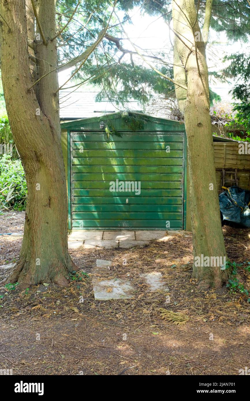 Tall trees block access to a car garage. Stock Photo