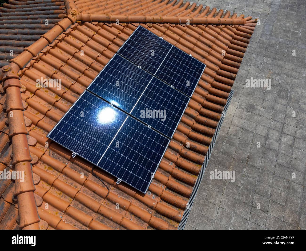 Three photovoltaic solar panels on the roof of a house Stock Photo