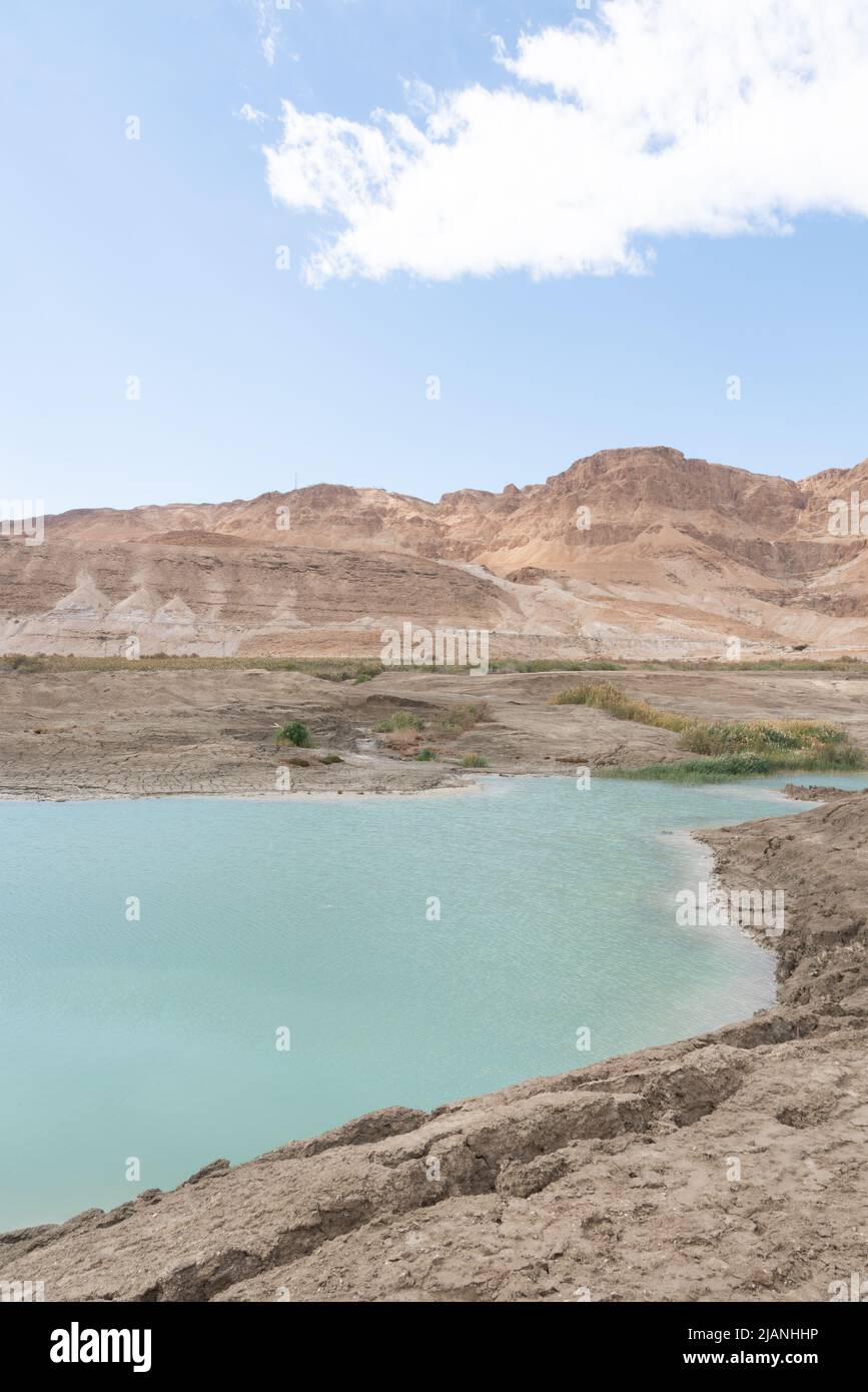 Sinkhole filled with turquoise water, near Dead Sea coastline. Hole