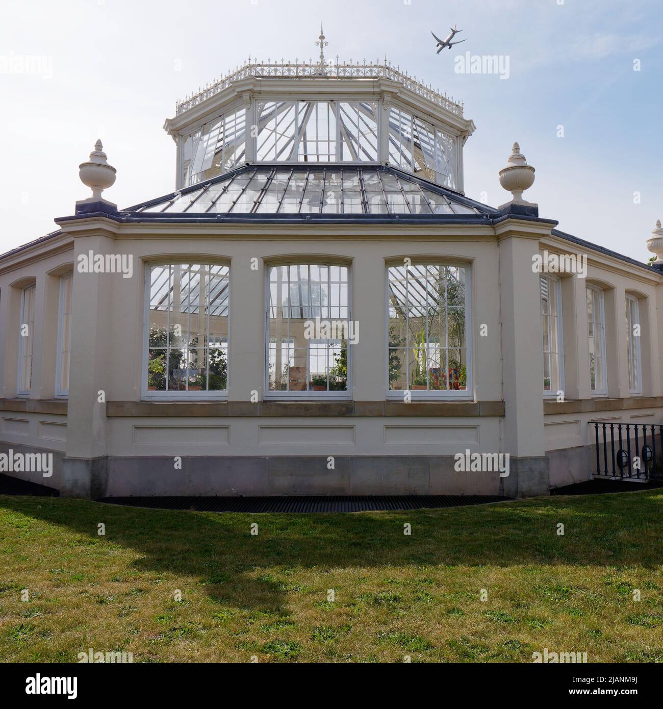 Richmond, Greater London, England, May 18 2022: Royal Botanic Gardens Kew. Temperate House as a plane flies overhead. Stock Photo
