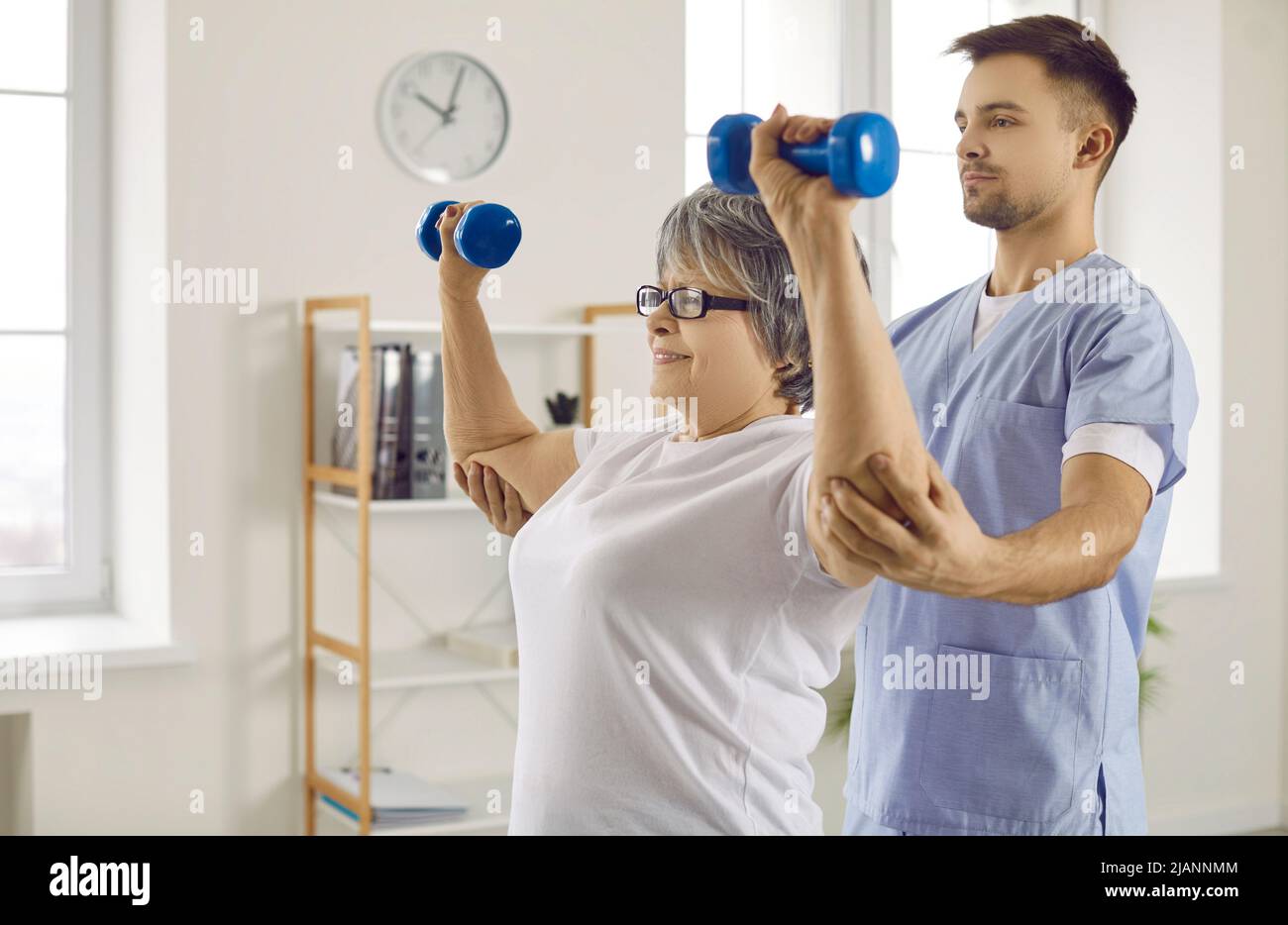 Physiotherapist work with aged patient in rehab clinic Stock Photo