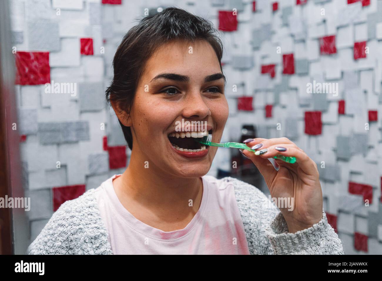 Young woman in front of mirror in the bathroom hires stock photography