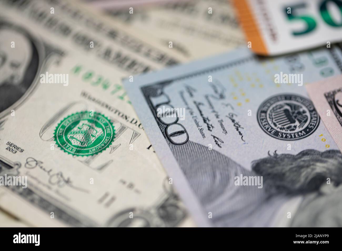 Closeup of one hundred dollar banknote next to one dollar and fifty euros. Stock Photo
