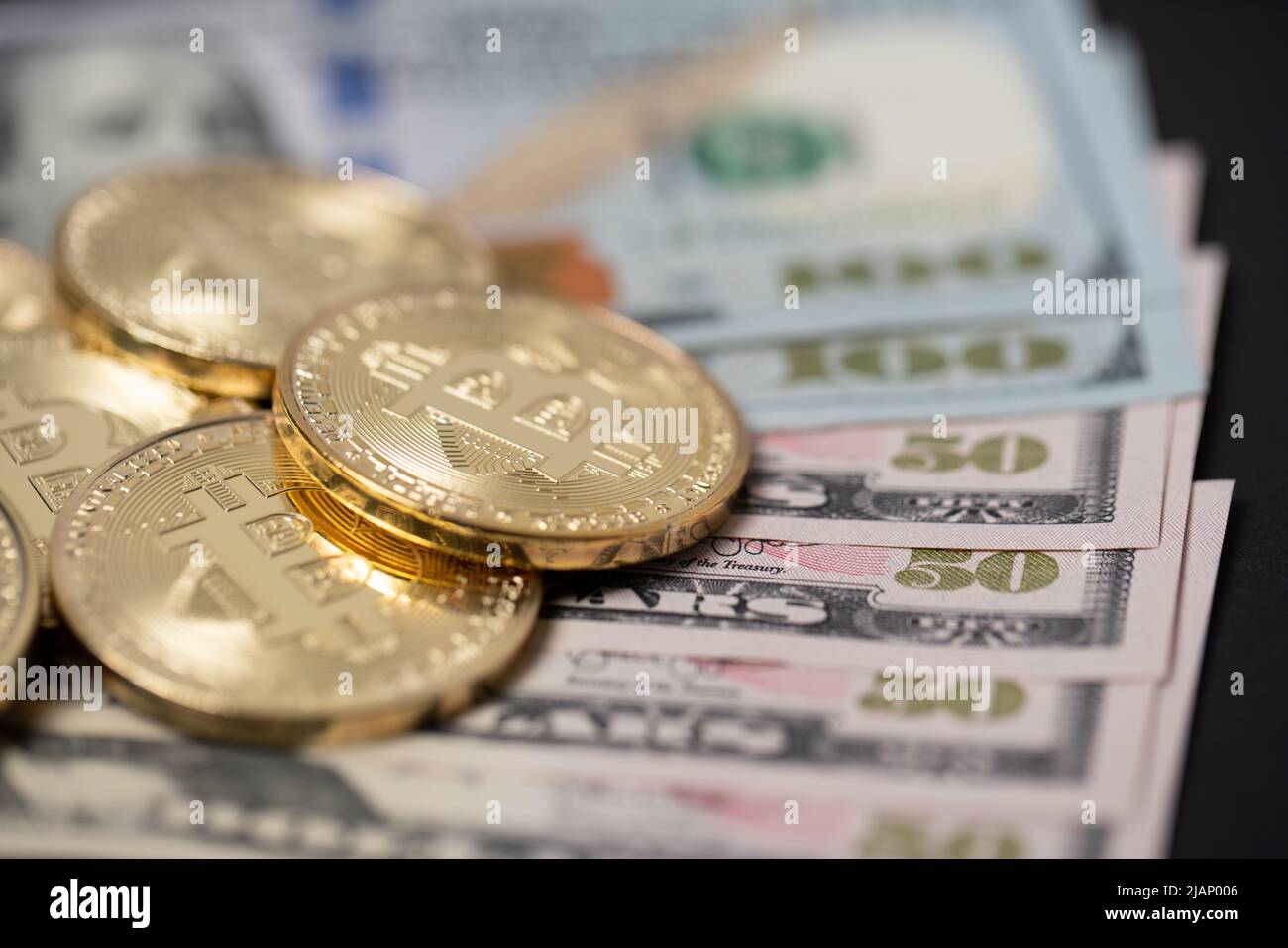 Piled up bitcoins on one hundred dollar bills. Exchange digital