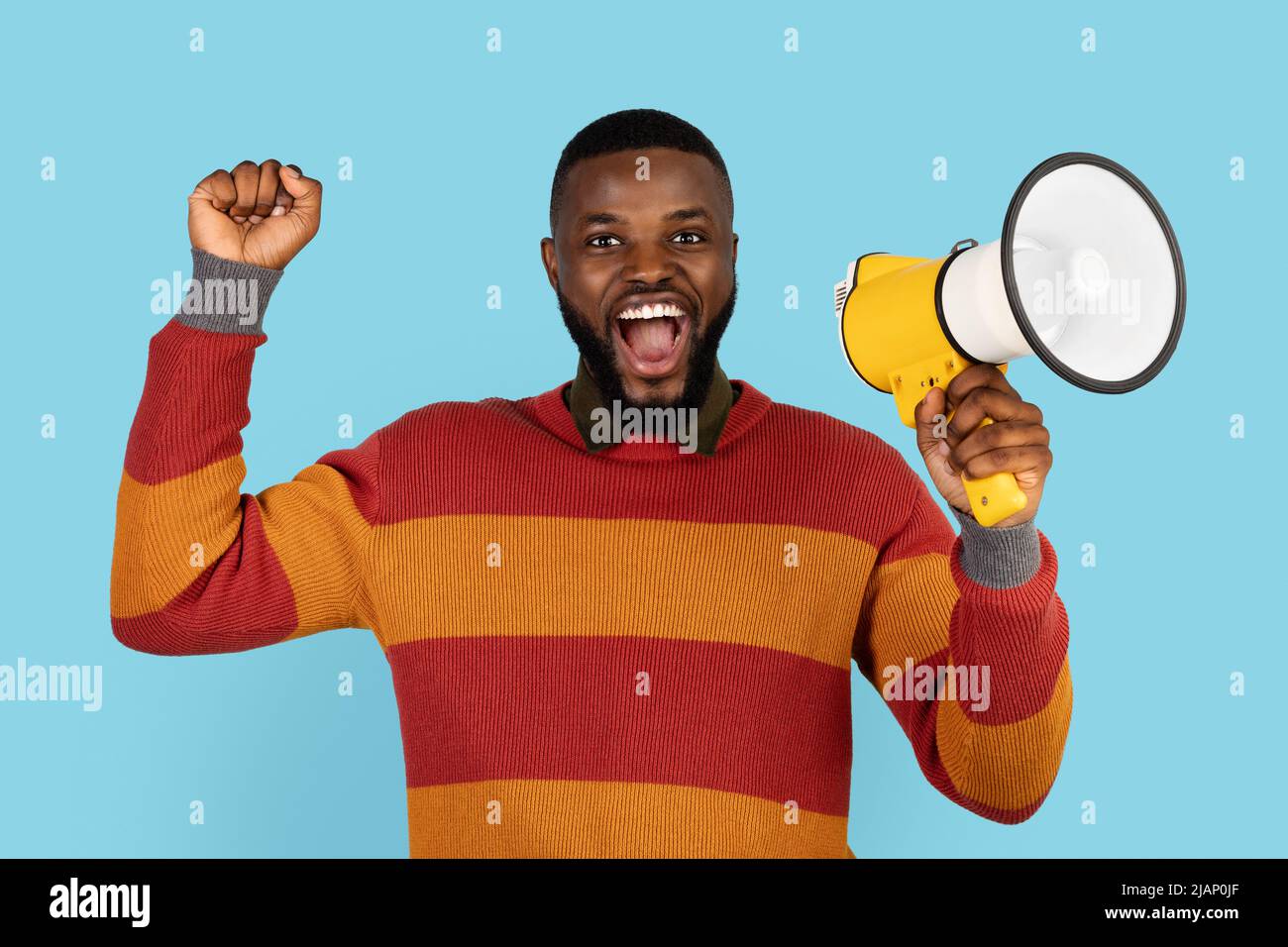 Portrait Of Joyful Black Man With Megaphone In Hands Making Announcement Stock Photo