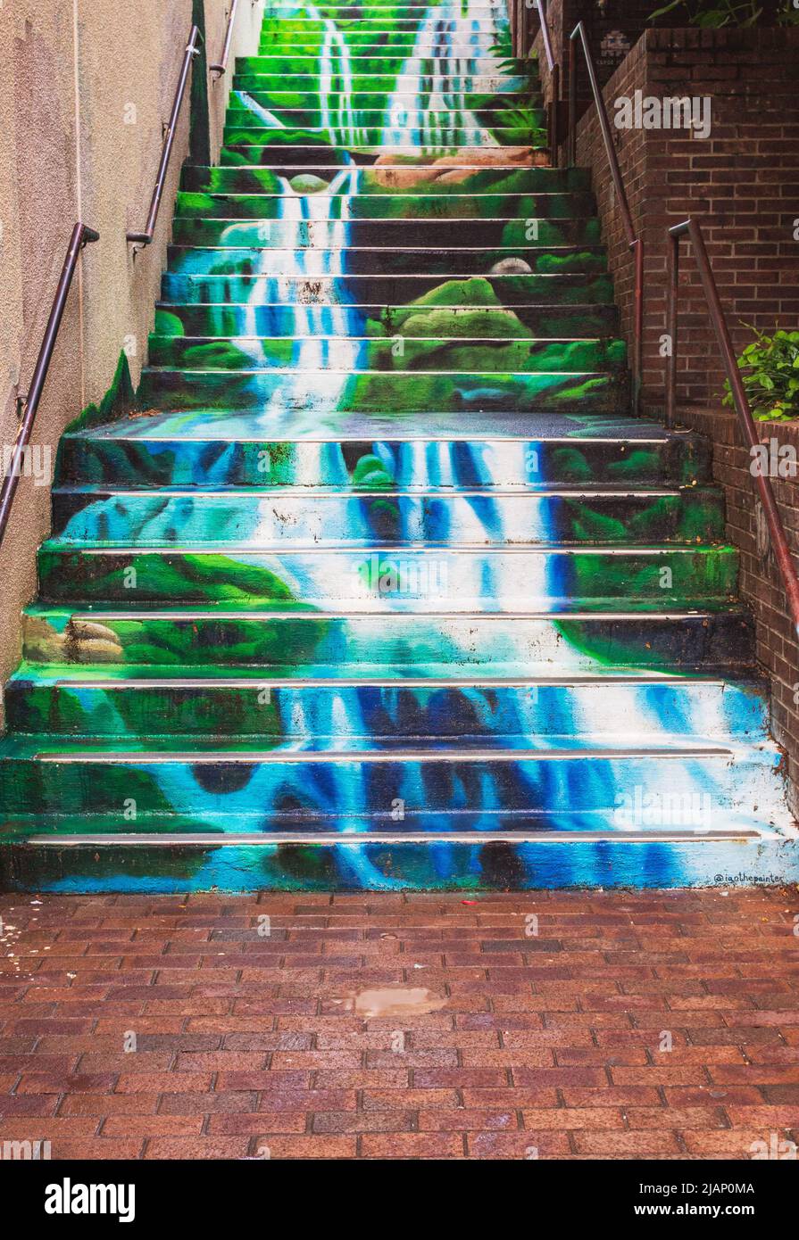 A mural of Catawba Falls by artist Ian Wilkinson seems to spill down a stairwell connecting Battery Park and Wall Street in Asheville, NC, USA Stock Photo