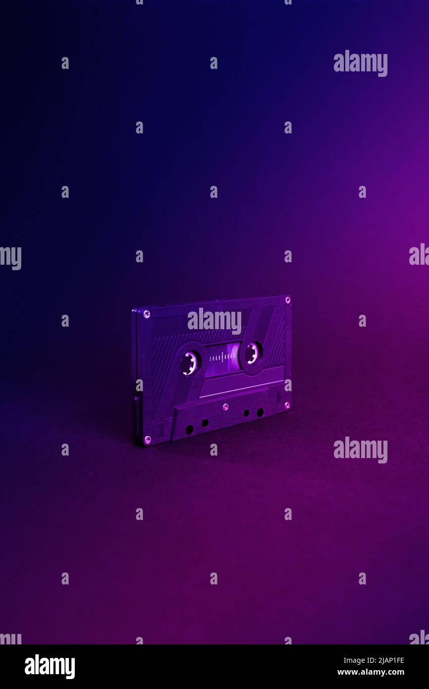 Audio cassette close up, isolated on purple and blue background. Analog