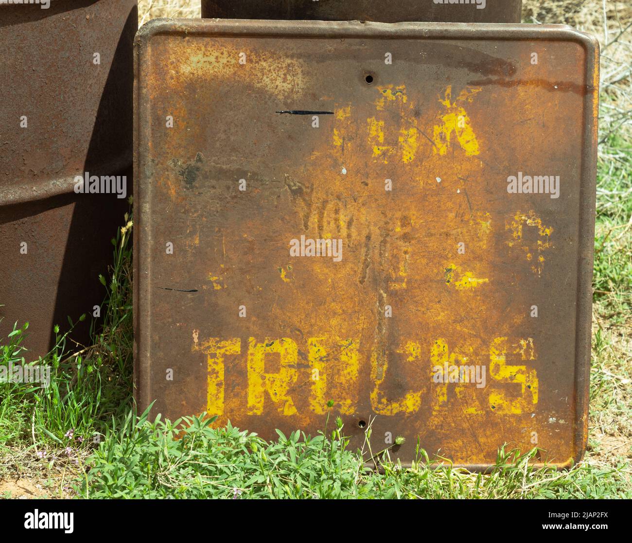 This square truck sign with yellow paint is rusted, old and not of any use. Trucks and this industry no longer see obsolete warning signs like this. Stock Photo