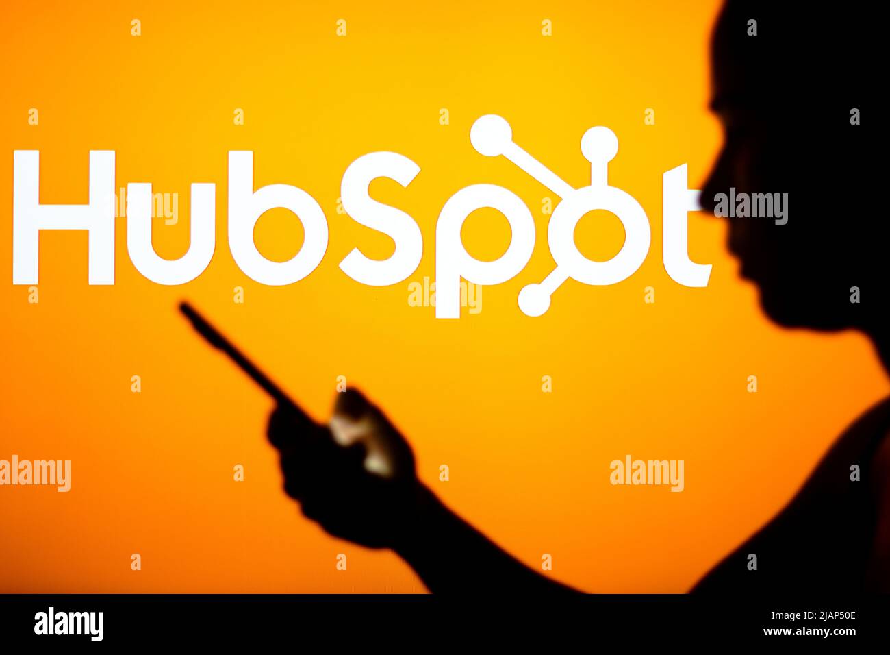 Brazil. 30th May, 2022. In this photo illustration, the HubSpot logo is seen in the background of a silhouetted woman holding a mobile phone. (Credit Image: © Rafael Henrique/SOPA Images via ZUMA Press Wire) Stock Photo