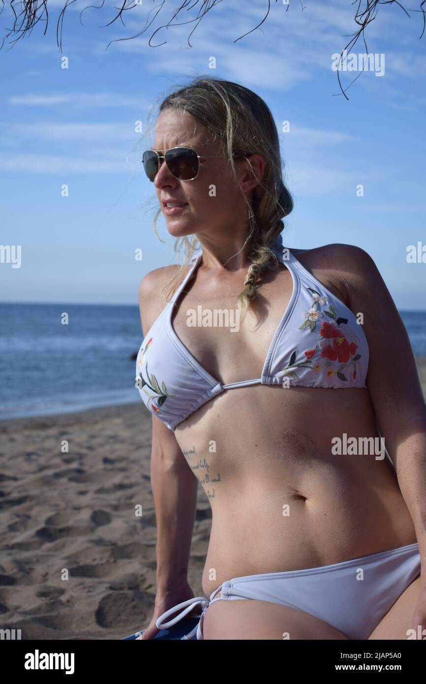Woman in bikini at beach, looking at ocean, in sunglasses, fitness, mom,  blonde, caucasian, white, sand Stock Photo - Alamy