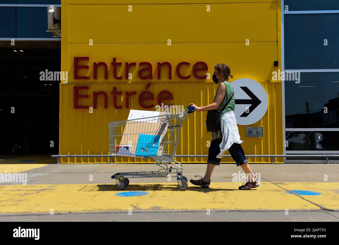 A shopper rolls a cart past the entrance at an Ikea furniture store in