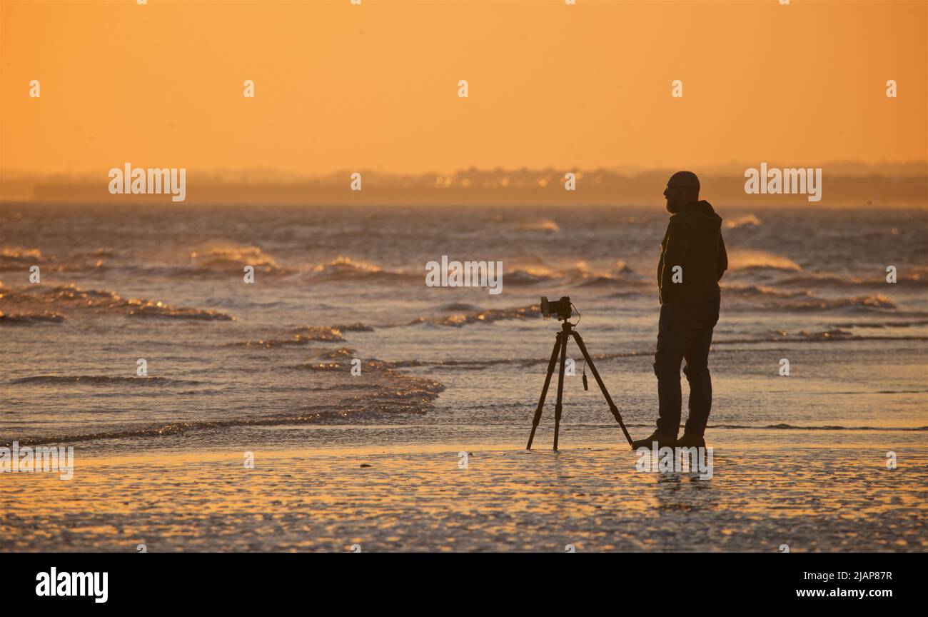 Dusk at low tide with photographer camera tripod hi-res stock ...