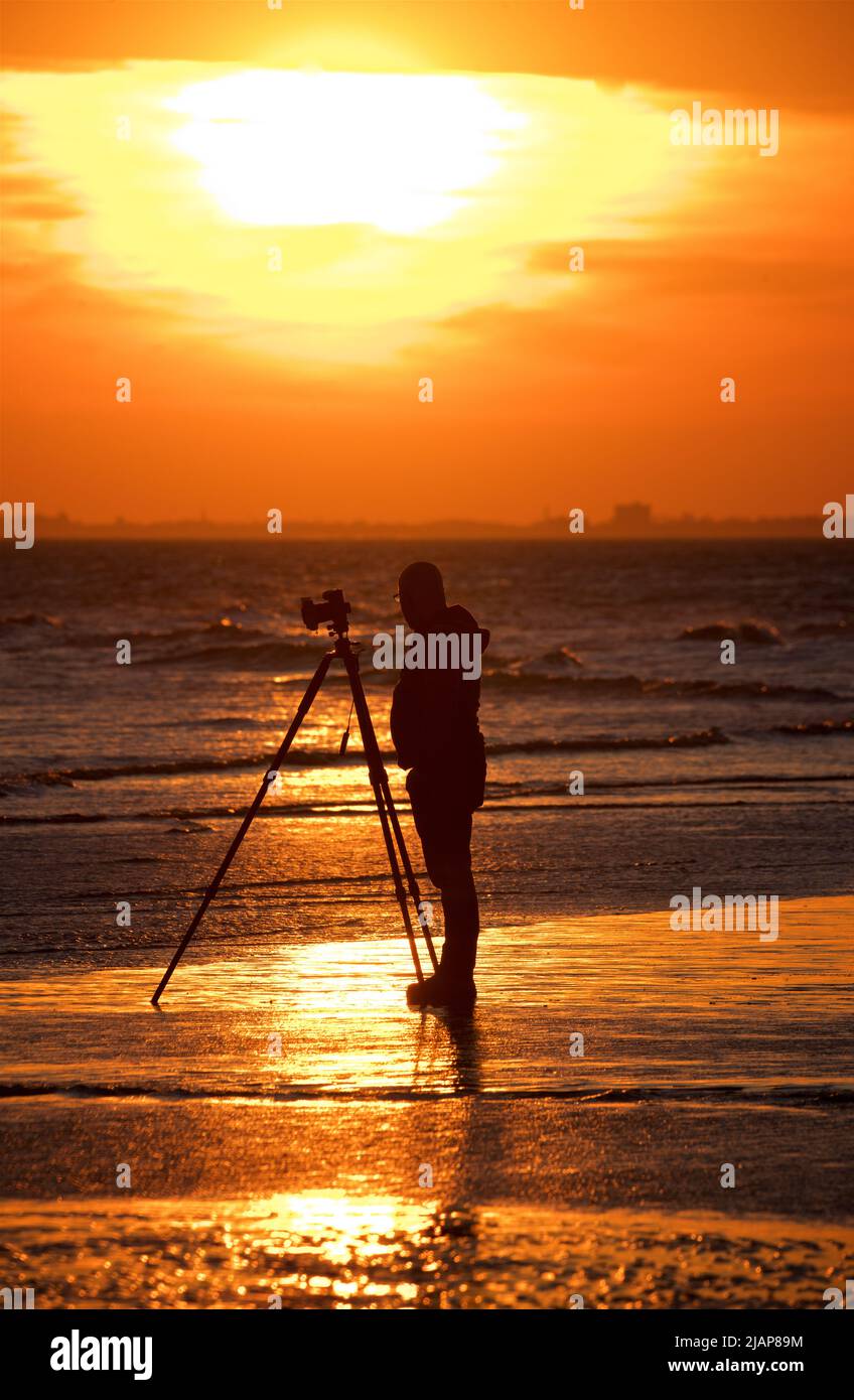 Dusk at low tide with photographer camera tripod hi-res stock ...