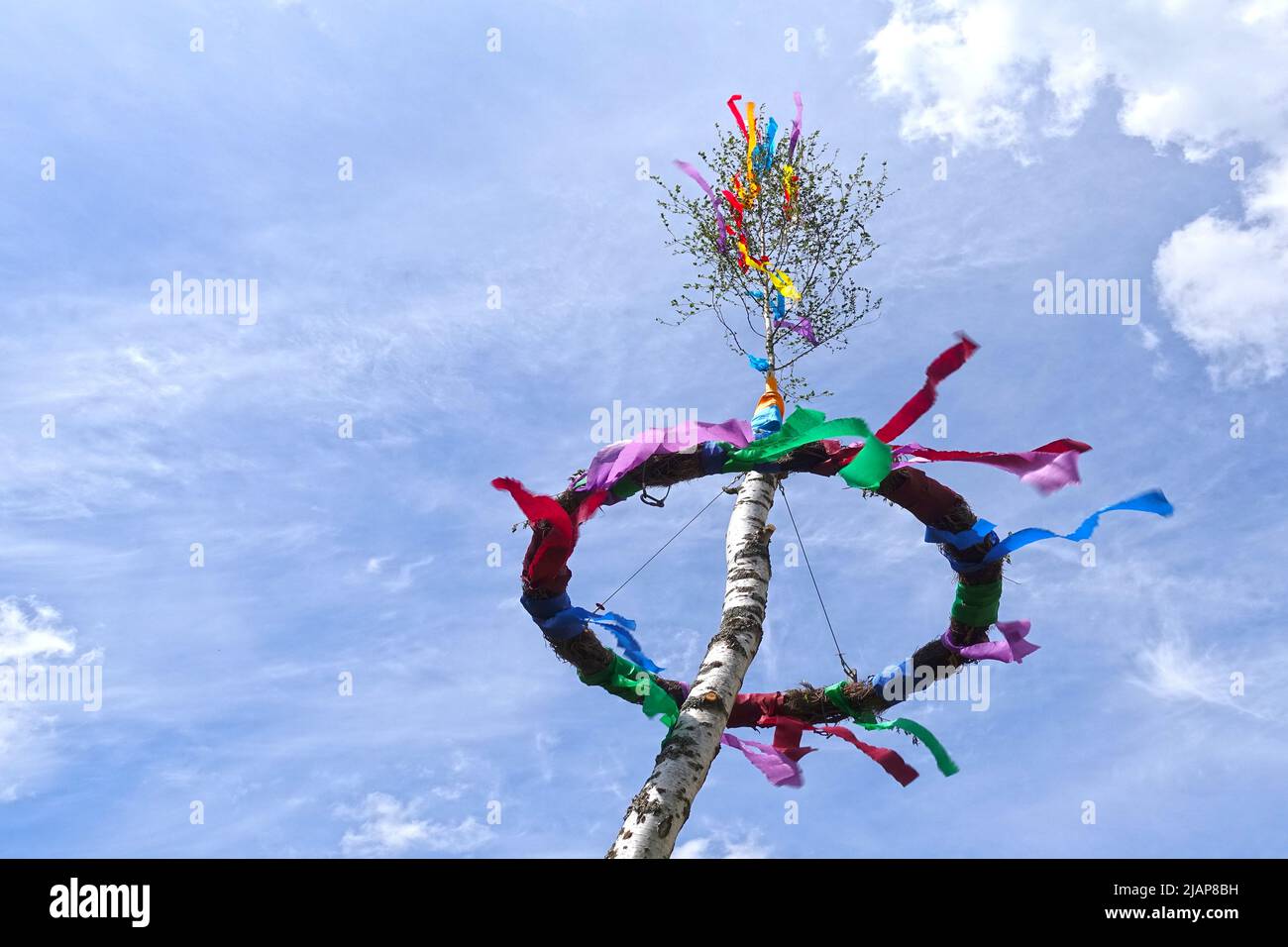 German may pole with may wreath with colorful ribbons, set up for the traditional may day celebration in Germany. Stock Photo