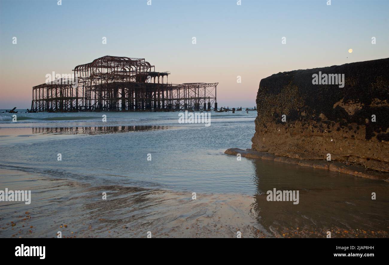 Rusting remains of the dilapidated West Pier at dawn low tide. Brighton & Hove, Sussex, England