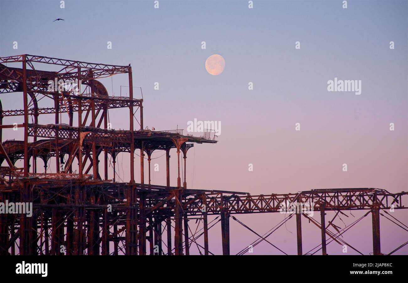 Detail of the rusting remains of the dilapidated West Pier at dawn low tide. Brighton & Hove, Sussex, England, UK. Full moon. Stock Photo