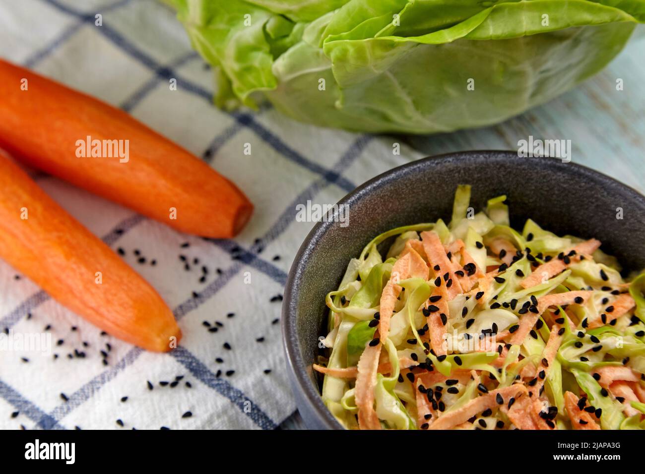 White cabbage and carrot coleslaw salad with black caraway seeds and