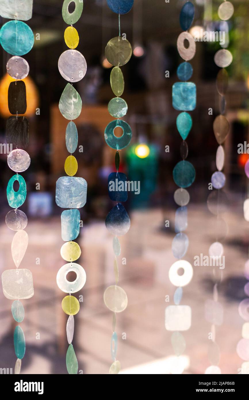 A wall hanging of geometric shapes on string hangs in the window of a boutique in Asheville, NC, USA Stock Photo