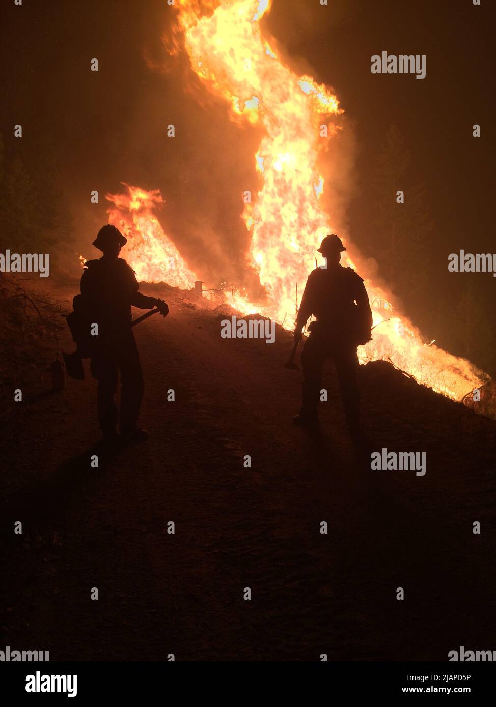 Wildfire raging with silhouettes of firefighters in foreground. Night ops continue on the Sunrise fire, Montana. Aravaipa Veteran Fire Crew.  United States of America  An optimised / enhanced version of a US Bureau of Land Management phot credit: BLM Stock Photo